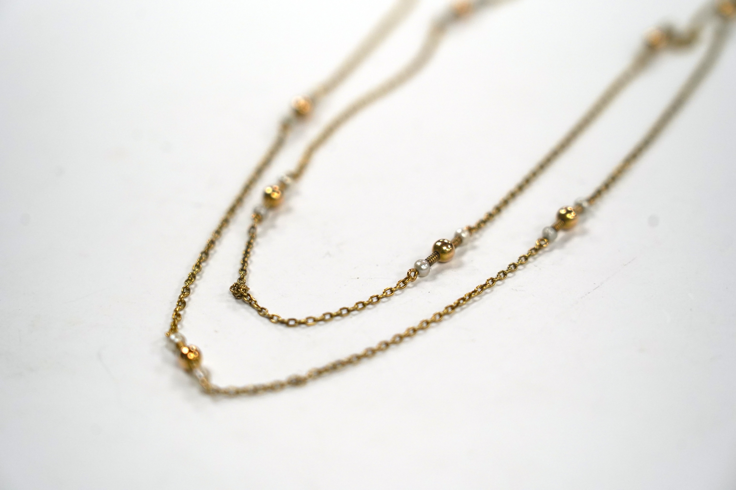 A 10k yellow metal and seed pearl set guard chain, 146cm, gross weight 14.2 grams.